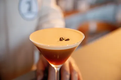 Cocktail crémeux servi dans une coupe, décoré de grains de café