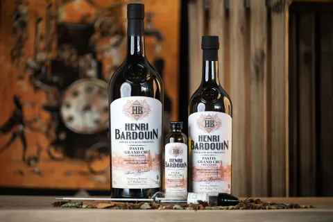 Bouteilles de Pastis Henri Bardouin Grand Cru dans un décor ancien
