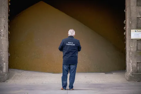 Un producteur de riz devant le stock de riz paddy