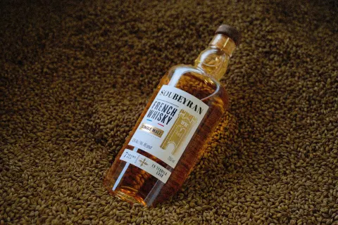 Bouteille de whisky Soubeyran couchée sur l'orge maltée