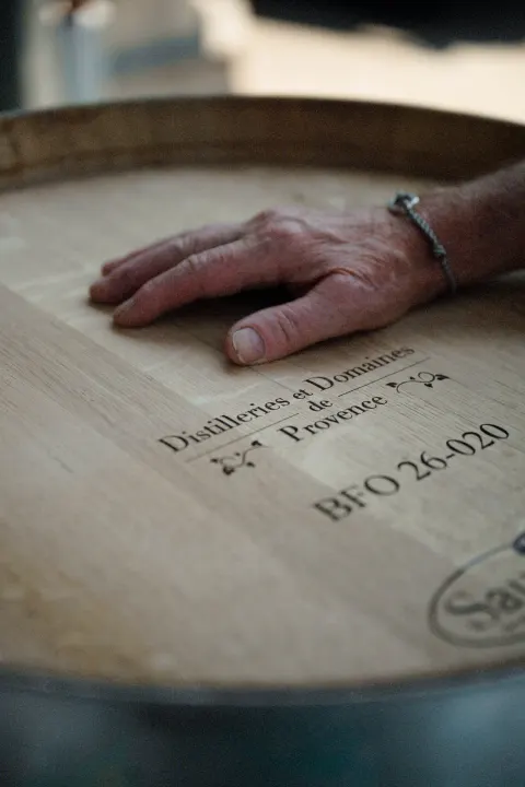 Main posée sur un fût marqué Distilleries et Domaines de Provence