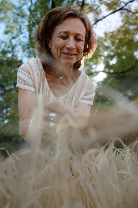 Une agricultrice sourit en caressant les épis d'orge